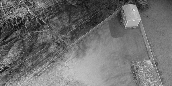 Bird’s eye view of garden with half dead grass and half bright green grass