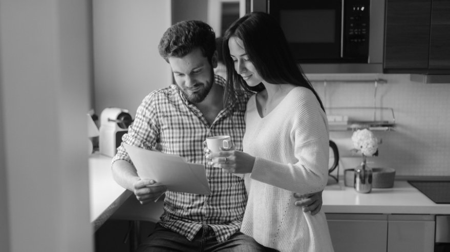 Couple reading paperwork in the kitchen