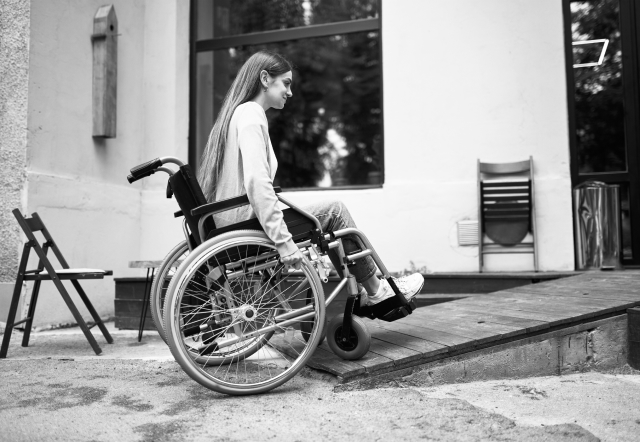 Lady in a wheelchair accessing her home with a new ramp funded by a home improvement loan.