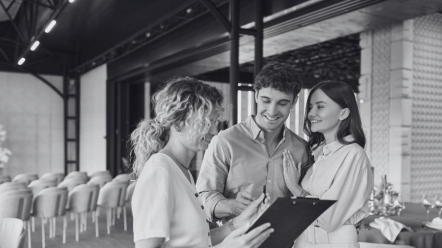 Couple with a wedding planner staring at a wedding list