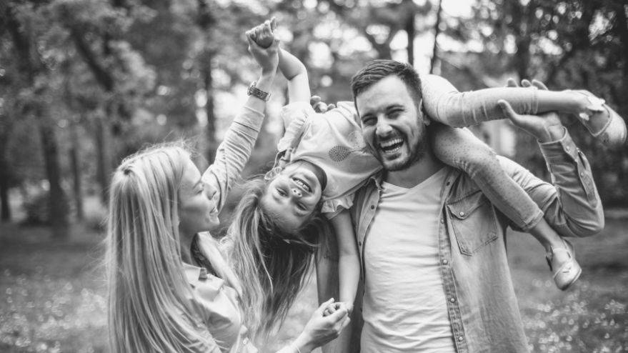 Image of a happy family playing together with a father lifting his daughter