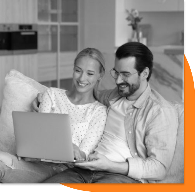 Couple holding a laptop in their hand smiling in their home