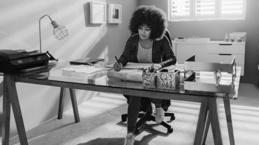Woman sat at her desk doing work at home