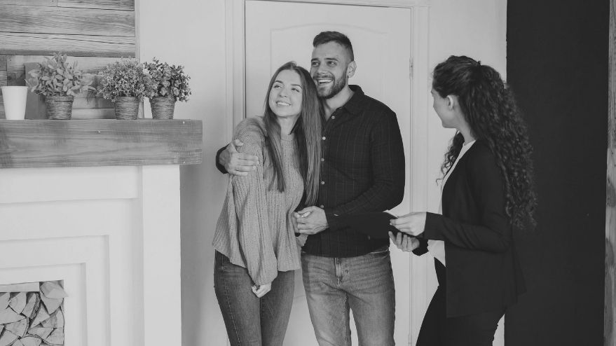 couple hugging beside realtor