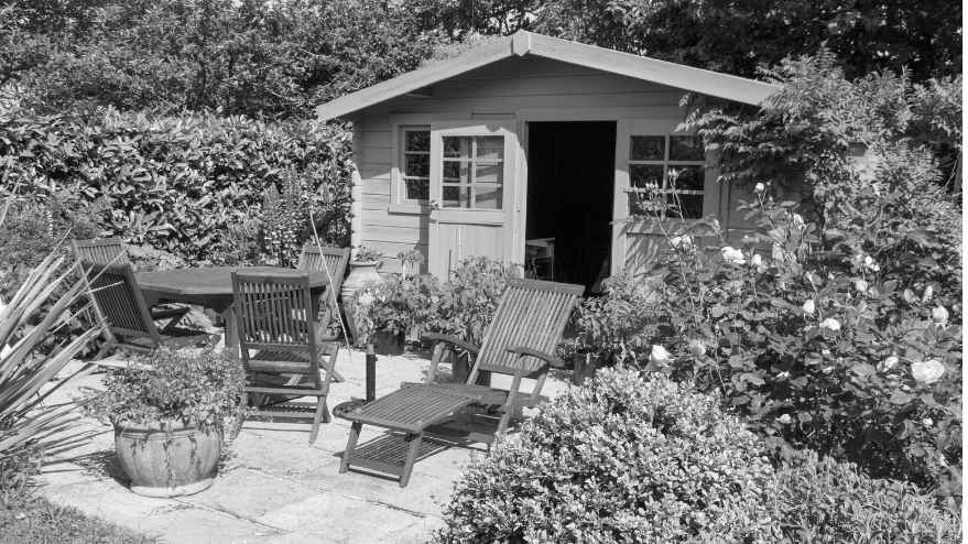 Image of a garden containing a garden room and some outdoor furniture