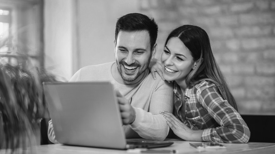 Couple looking at their laptop and smiling