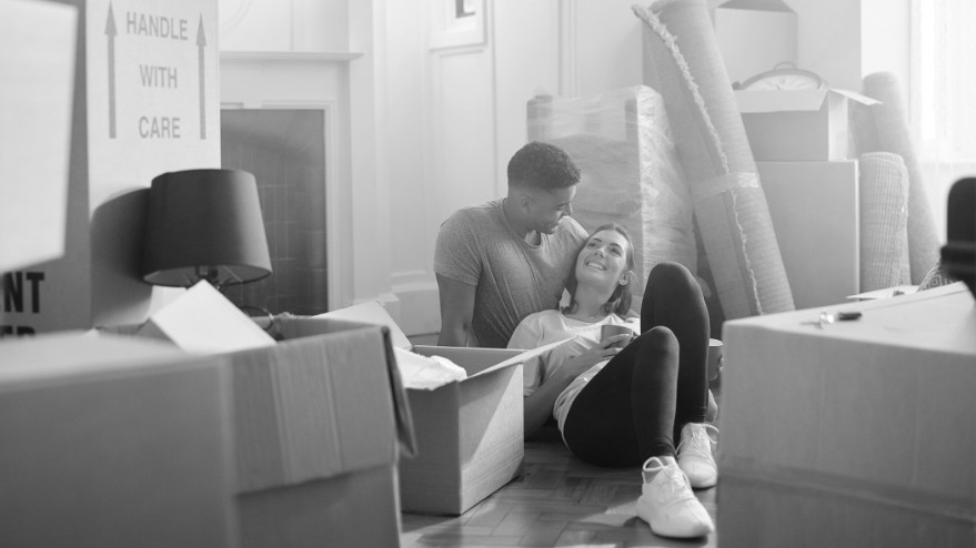 Couple lying down between boxes after moving in