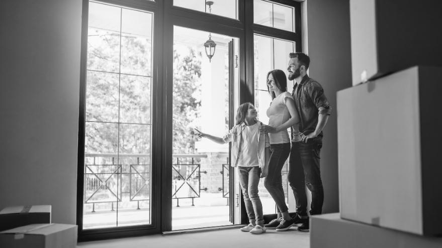 Child with her parents walking out of the door of their new home